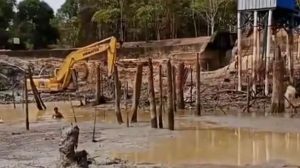 Proses normalisasi kolong sumber air baku SPAM Rindik di Desa Rindik, Kecamatan Toboali, terus dikebut. Alat berat dikerahkan mengangkat sedimen lumpur dan kayu-kayu yang selama ini mencemari kualitas air, sementara sejumlah pekerja turun langsung membersihkan pinggir kolong yang nyaris kering akibat kemarau panjang. (Foto: SUARABAHANA.COM)